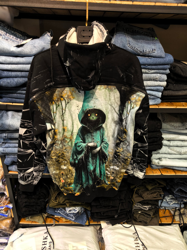 هودی مشکی طرح شخصیت مرموز با شنل سبز در جنگل – کالکشن خاص اورجینال دیلم